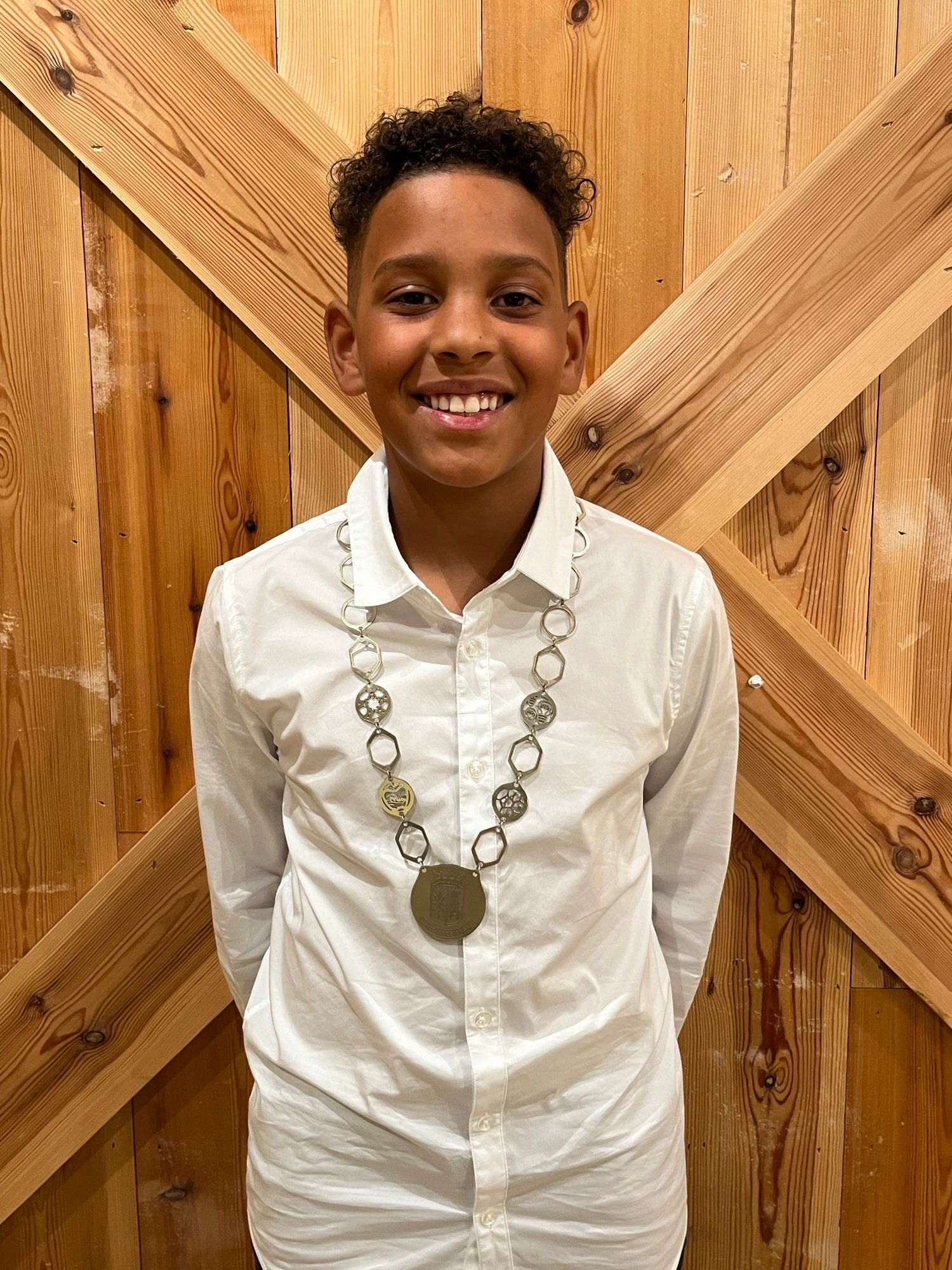 Kinderburgemeester Tyrese poseert met de ambtsketting